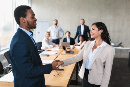 Business Deal. African Businessman And Latin Businesswoman Shaking Hands In Agreement After Successful Negotiations During Corporate Meeting In Modern Office. Two Entrepreneurs Handshaking Concept