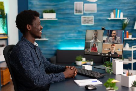 African student having online videocall meeting conference with remote university team discussing business ideas in living room. Videoconference telework call on computer computer screen